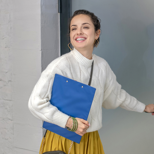 young-woman-standing-at-the-door-holding-door-han-2024-10-11-19-24-50-utc